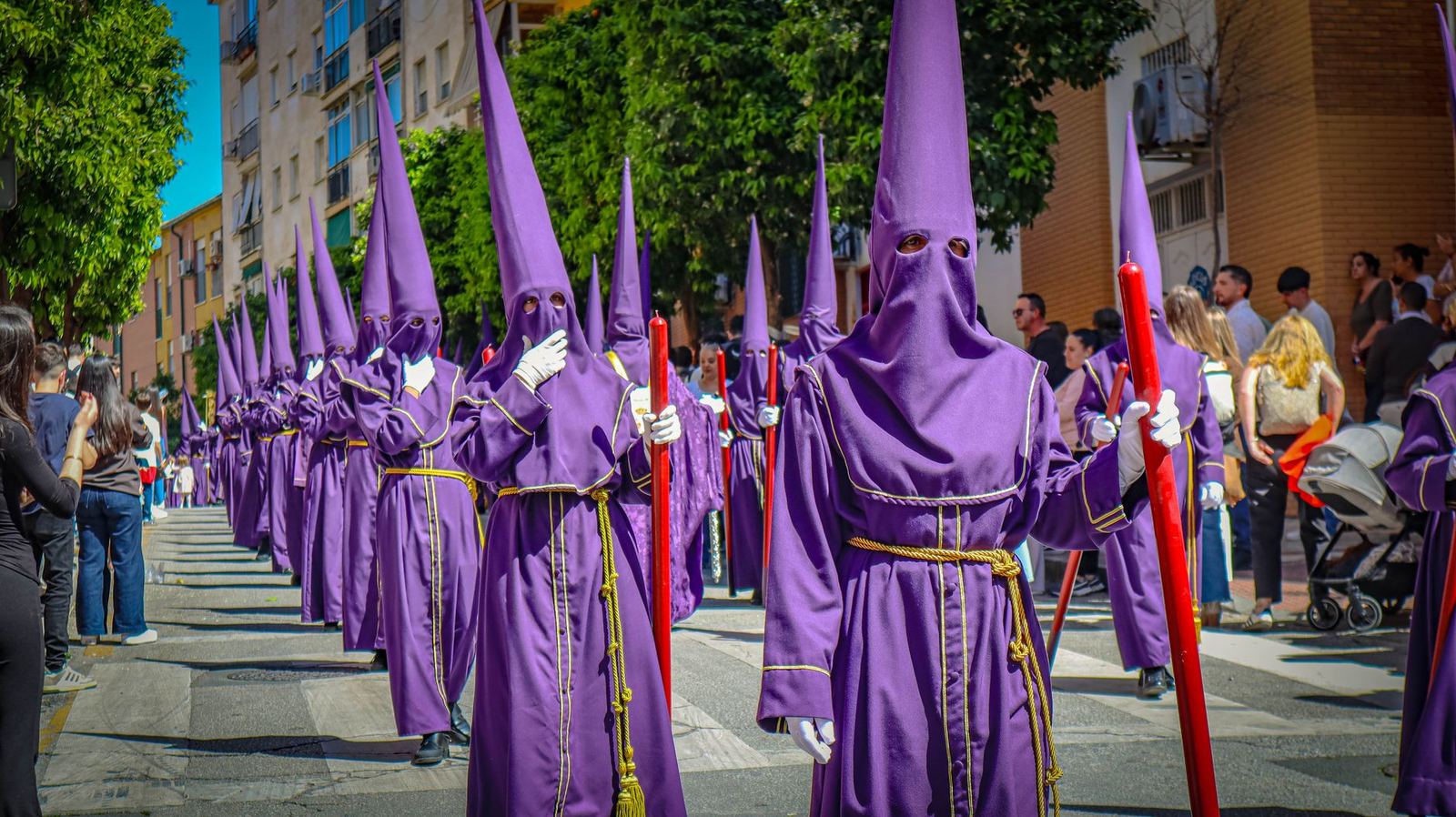 Nazarenos in purple robes participate in a Semana Santa procession in Málaga, Spain.